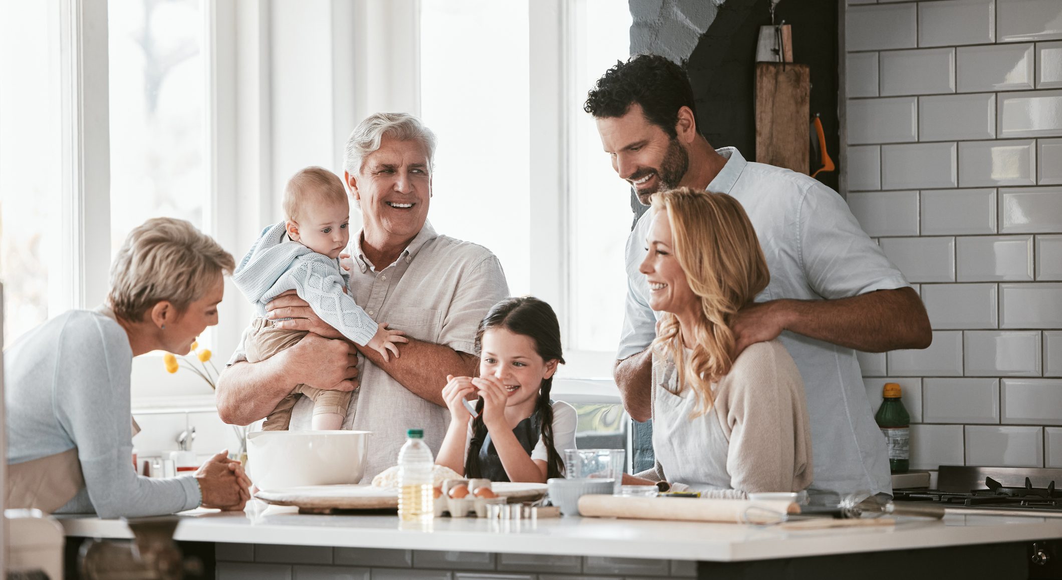 Multigenerational family, love and cooking in home kitchen, bonding or having fun. Support, care and grandparents, father and mother, baby and girl baking, learning and talking while enjoying quality time together